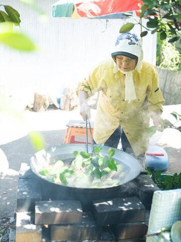 同じ鍋で続けて新しいハチクをゆでる。3回目からはツバキの枝葉を追加
