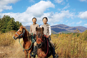 筆者（42歳）と妻の麻弥。妻が乗っているのが母馬の花恵山（北海道和種）
